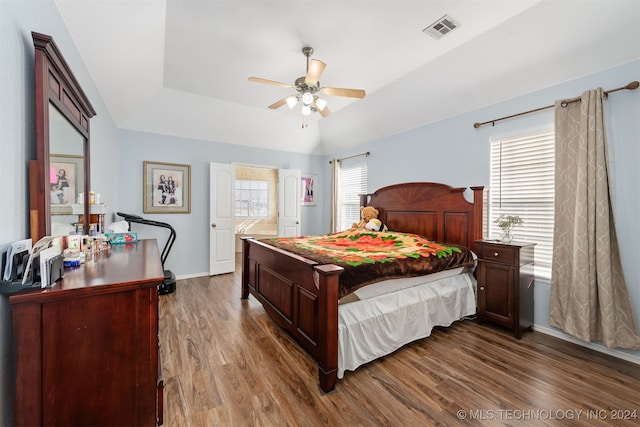 bedroom with a tray ceiling, ceiling fan, and wood-type flooring