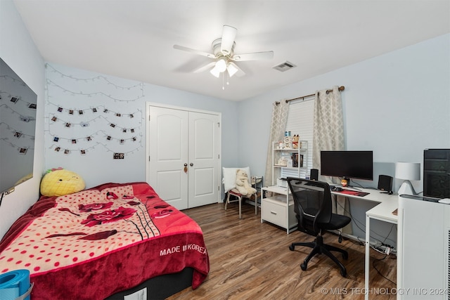 bedroom with ceiling fan, a closet, and hardwood / wood-style flooring