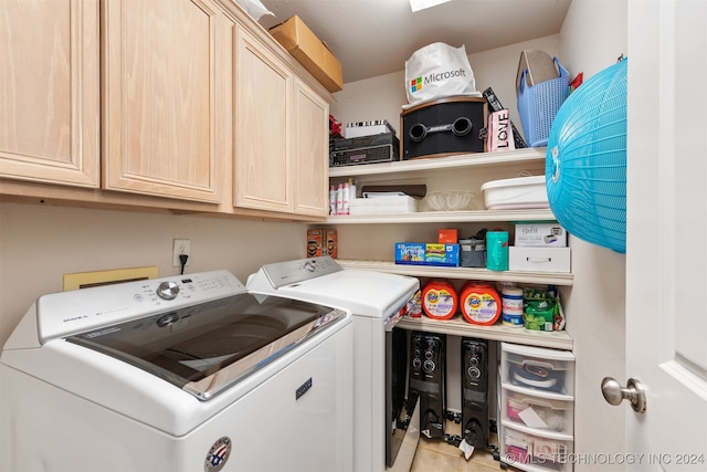 clothes washing area with light tile patterned floors, cabinets, and independent washer and dryer