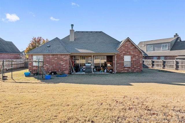 back of property with a patio area and a lawn