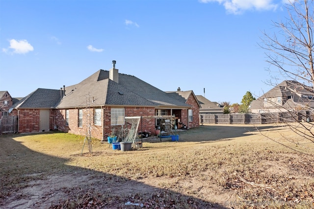 rear view of property with a lawn