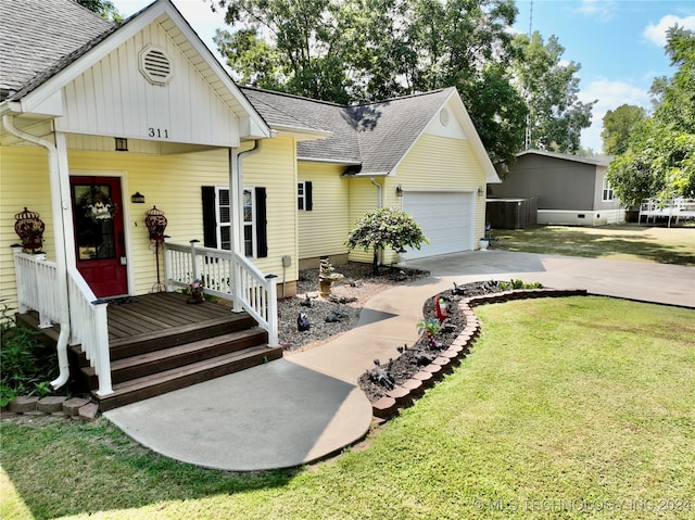 view of front of property featuring a garage, a front lawn, and a deck