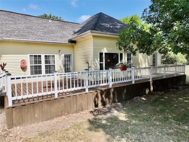 back of house featuring a lawn and a wooden deck