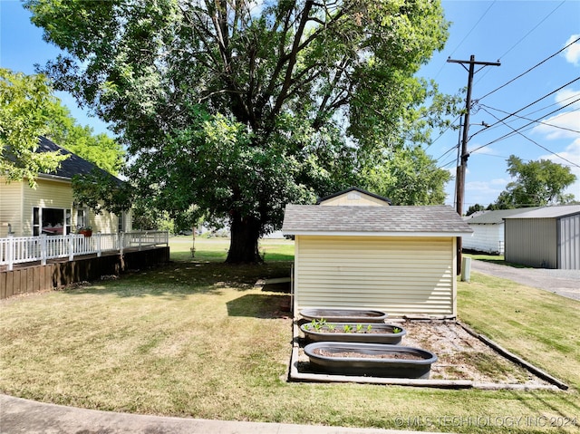 view of yard with a wooden deck and a storage shed