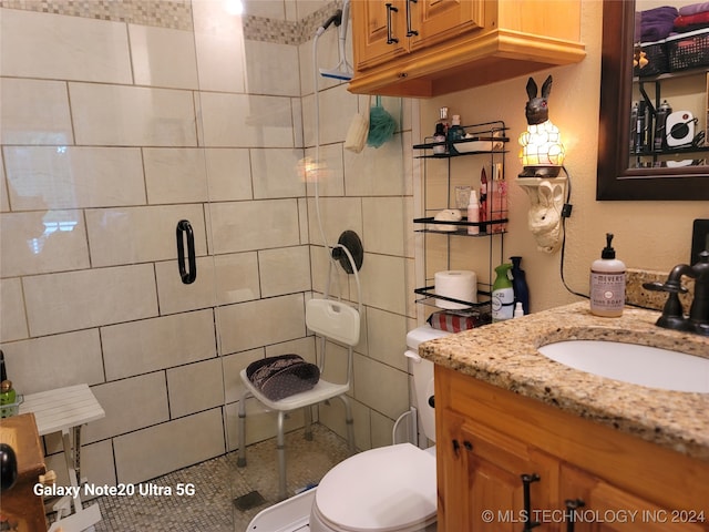 bathroom with toilet, vanity, and tile walls