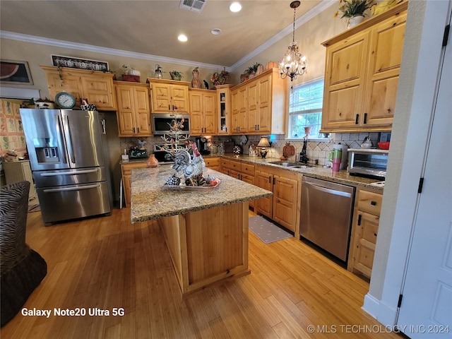 kitchen featuring a center island, light hardwood / wood-style flooring, sink, light stone countertops, and appliances with stainless steel finishes