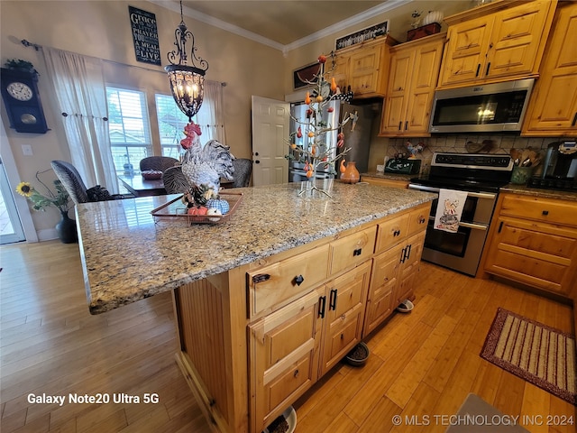 kitchen featuring crown molding, stainless steel appliances, light hardwood / wood-style floors, and a center island