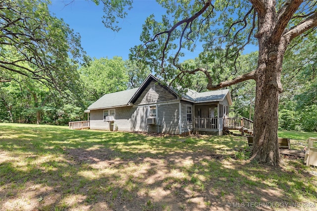 rear view of property with cooling unit, a lawn, and a deck