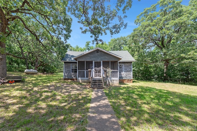 view of front of house featuring a sunroom and a front lawn