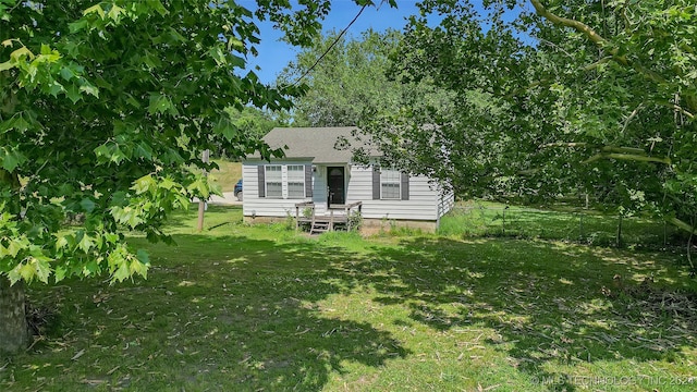 rear view of house featuring a lawn