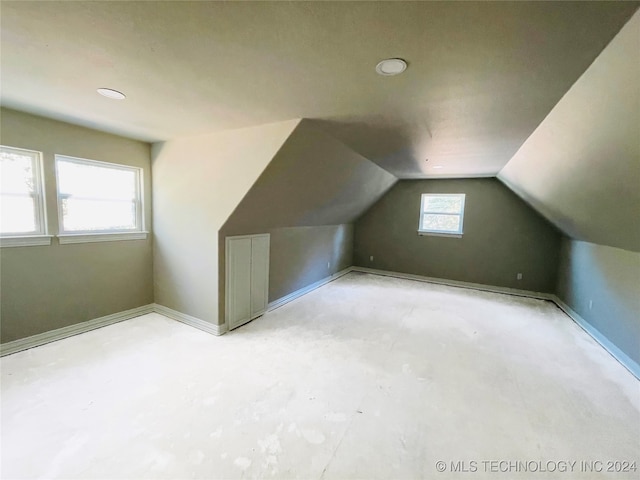 additional living space featuring lofted ceiling and a healthy amount of sunlight