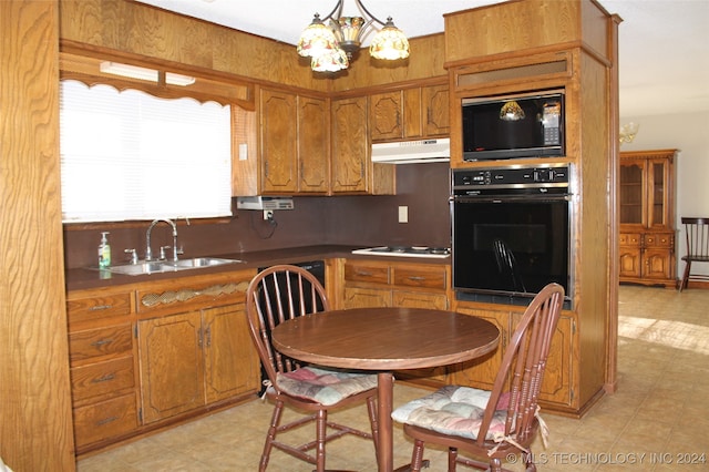 kitchen featuring pendant lighting, an inviting chandelier, sink, and black appliances