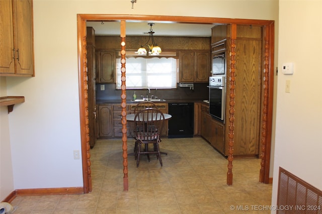 kitchen with oven, sink, pendant lighting, and black dishwasher