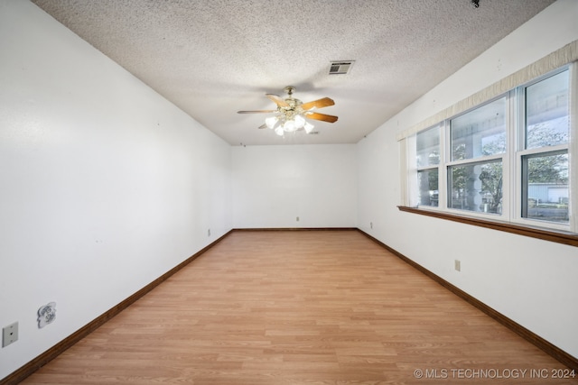 spare room with ceiling fan, a textured ceiling, and light hardwood / wood-style flooring