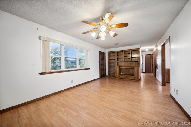 unfurnished living room featuring ceiling fan, a textured ceiling, and light wood-type flooring