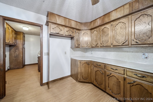 kitchen with a textured ceiling and light hardwood / wood-style flooring