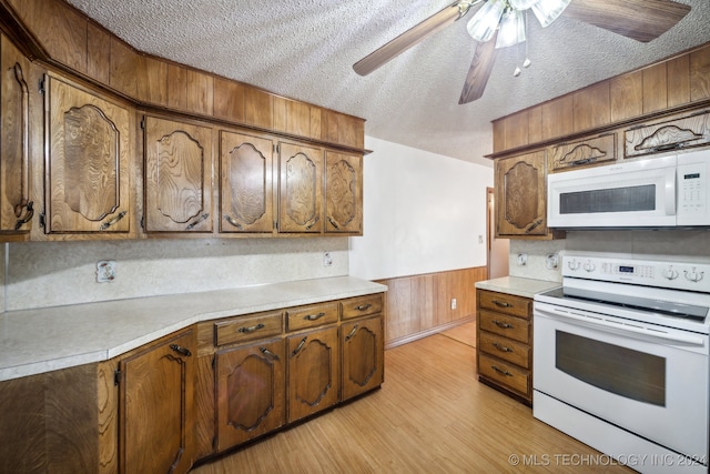 kitchen featuring tasteful backsplash, ceiling fan, a textured ceiling, white appliances, and light wood-type flooring