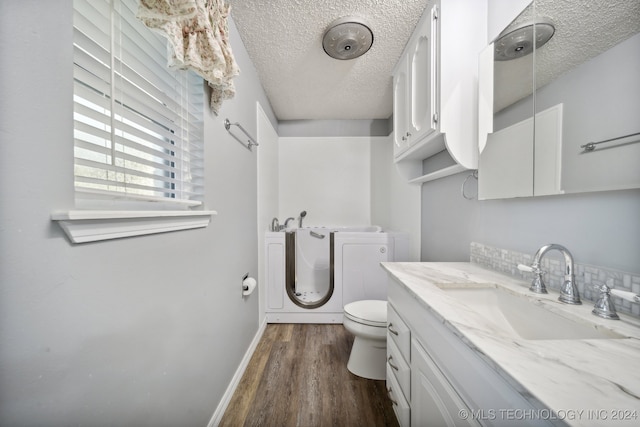 bathroom featuring hardwood / wood-style floors, a textured ceiling, toilet, and vanity