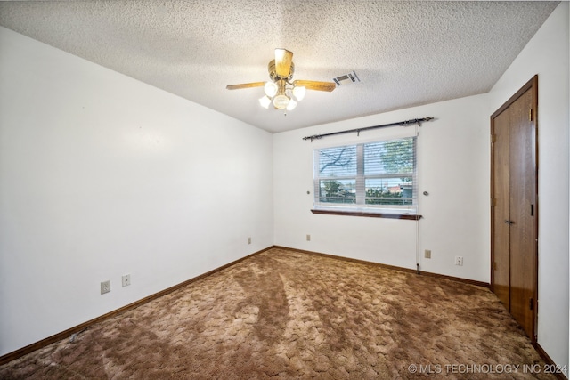 empty room with a textured ceiling, ceiling fan, and carpet floors