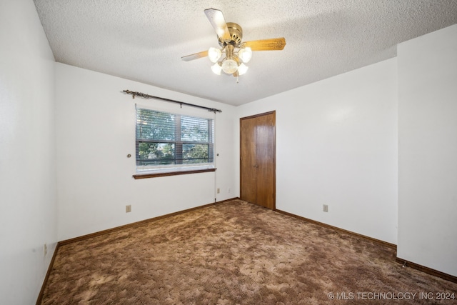 carpeted empty room featuring ceiling fan and a textured ceiling