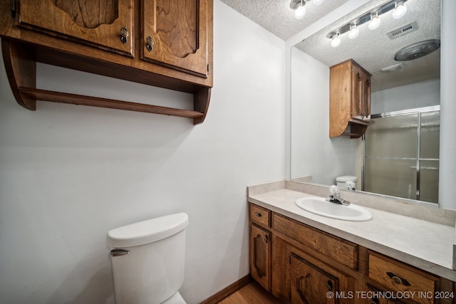 bathroom featuring hardwood / wood-style floors, vanity, a textured ceiling, and toilet