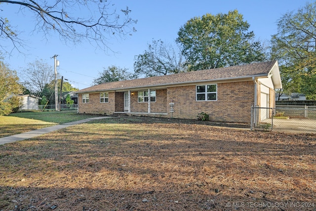 single story home with a front yard and a storage shed