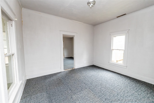 carpeted empty room featuring crown molding