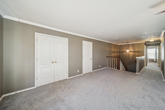 carpeted spare room featuring crown molding