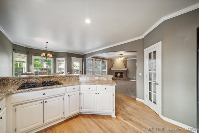 kitchen with white cabinetry, light hardwood / wood-style floors, black gas cooktop, and crown molding