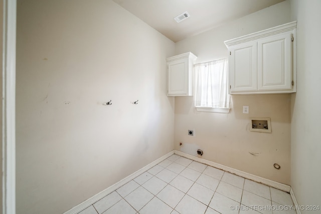 laundry area featuring hookup for an electric dryer, washer hookup, hookup for a gas dryer, light tile patterned floors, and cabinets