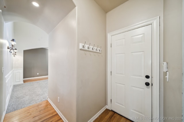 corridor featuring wood-type flooring and lofted ceiling