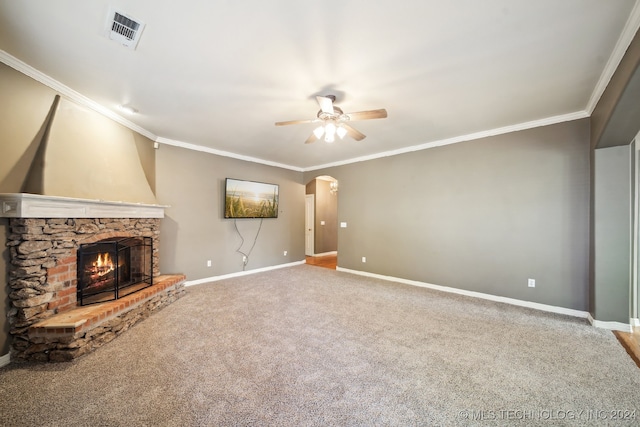 unfurnished living room featuring ornamental molding, a fireplace, ceiling fan, and carpet floors