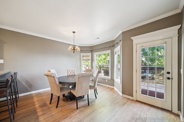 dining area with ornamental molding, light wood-type flooring, a wealth of natural light, and a chandelier