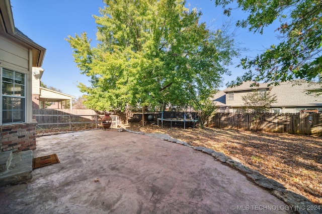 view of yard featuring a trampoline and a patio area