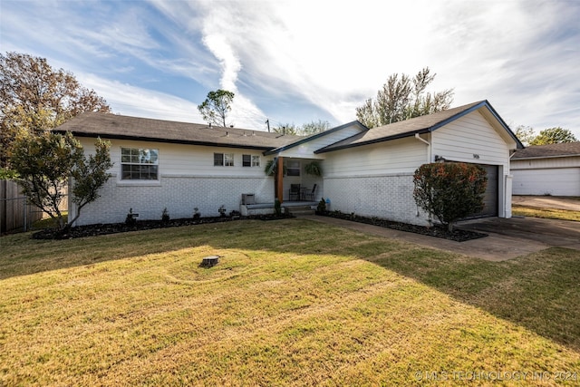 ranch-style home featuring a garage and a front lawn