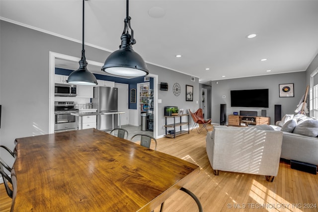 dining area featuring light hardwood / wood-style floors and crown molding