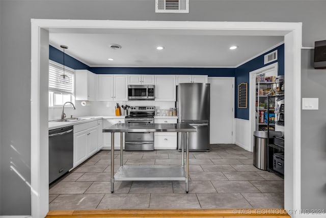 kitchen with white cabinetry, sink, appliances with stainless steel finishes, pendant lighting, and decorative backsplash