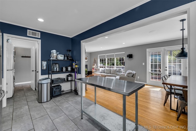 kitchen with stacked washer and dryer, crown molding, and hardwood / wood-style flooring