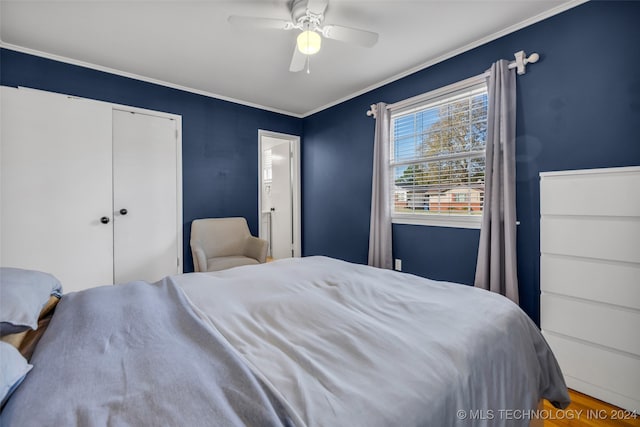 bedroom with a closet, hardwood / wood-style flooring, ceiling fan, and crown molding