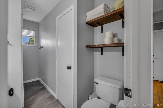 bathroom with hardwood / wood-style flooring and toilet