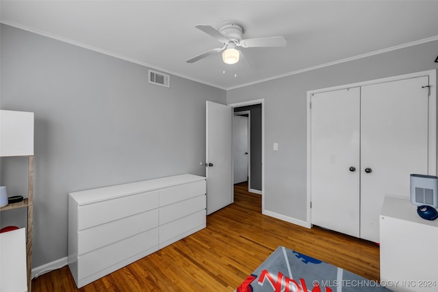 bedroom with ornamental molding, a closet, light wood-type flooring, and ceiling fan