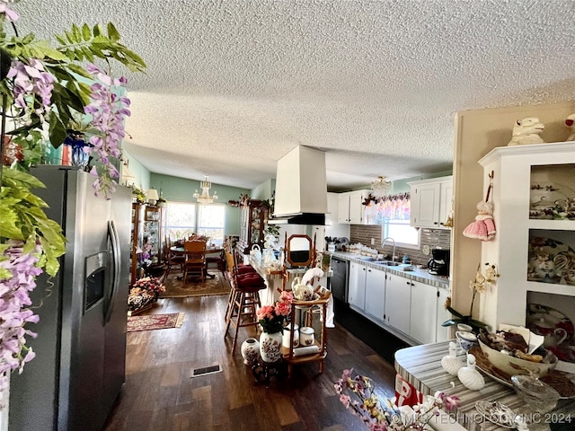 kitchen featuring dark wood-type flooring, stainless steel appliances, a healthy amount of sunlight, and white cabinets