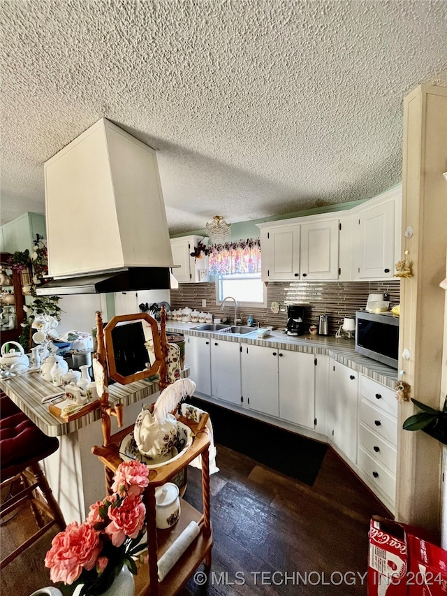 kitchen featuring white cabinetry, sink, dark hardwood / wood-style floors, a textured ceiling, and decorative backsplash