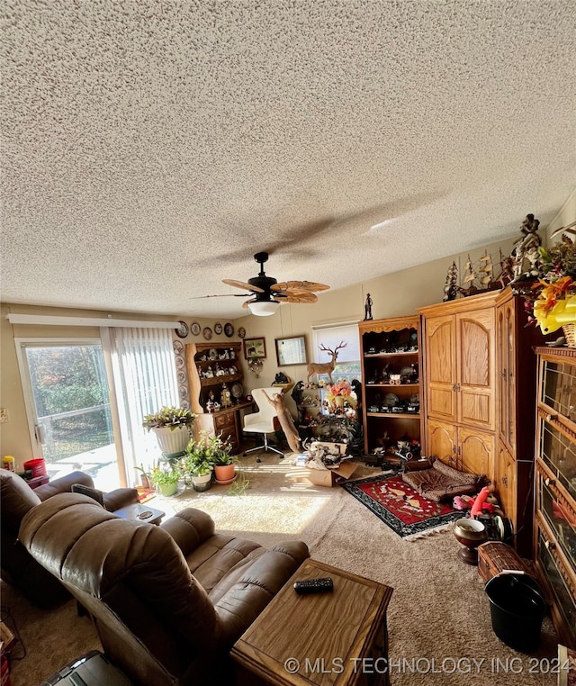 carpeted living room featuring ceiling fan and a textured ceiling