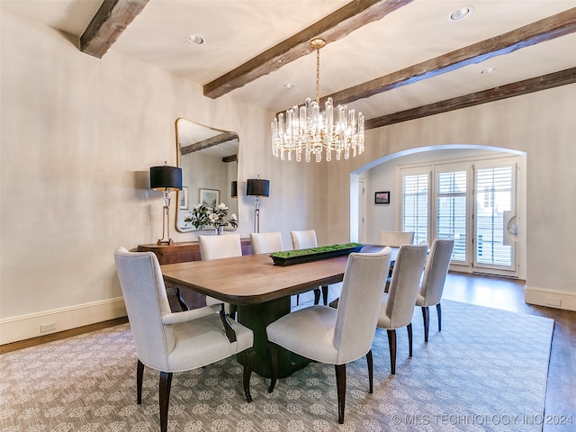 dining area featuring arched walkways, beam ceiling, baseboards, and wood finished floors