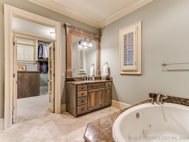 bathroom featuring ornamental molding, a jetted tub, tile patterned flooring, baseboards, and vanity