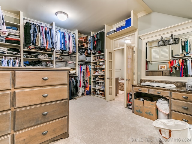 walk in closet featuring carpet floors and vaulted ceiling