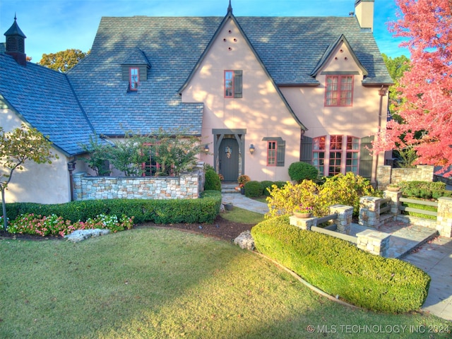 english style home with a front lawn