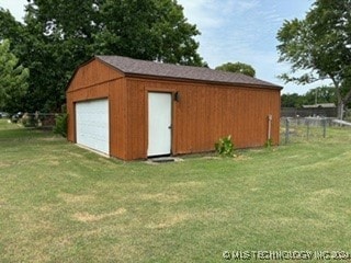 view of outdoor structure featuring a yard and a garage