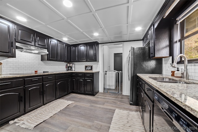 kitchen featuring black appliances, tasteful backsplash, sink, and light hardwood / wood-style flooring